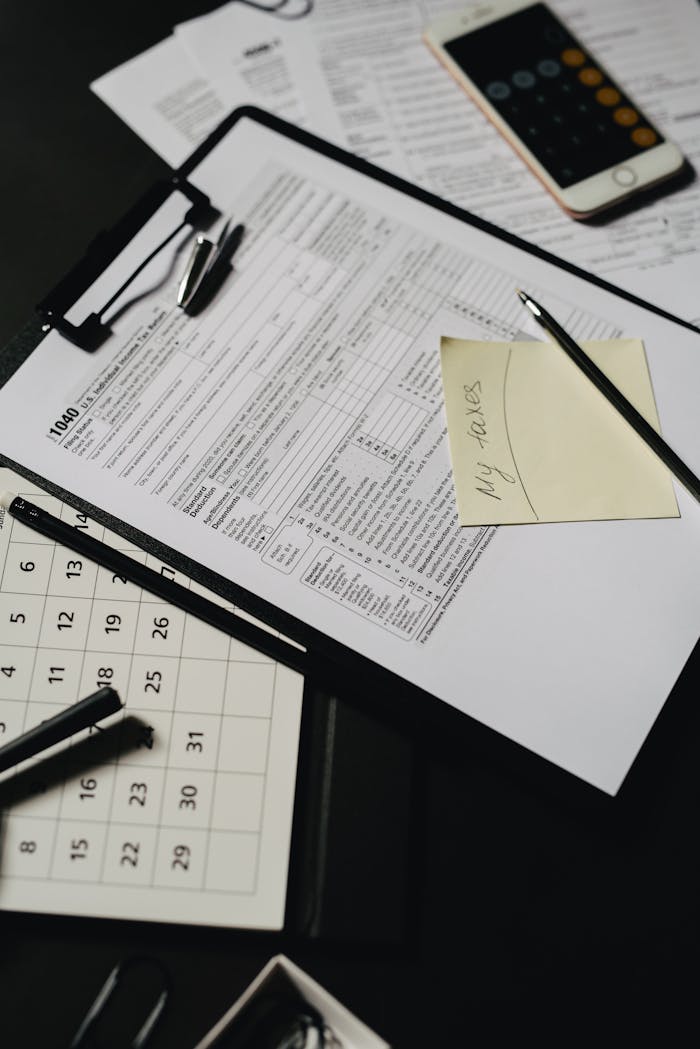 Close-up view of a neatly organized desk with tax forms, calculator, and stationery for financial planning.