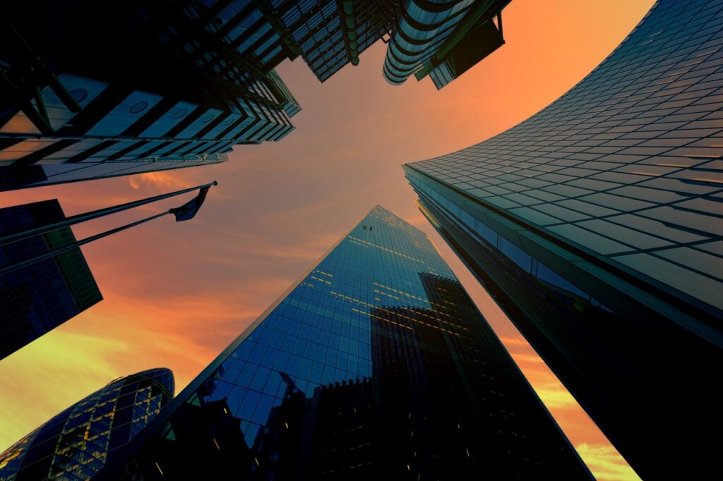 Low angle view of modern skyscrapers against a vibrant sunset sky.