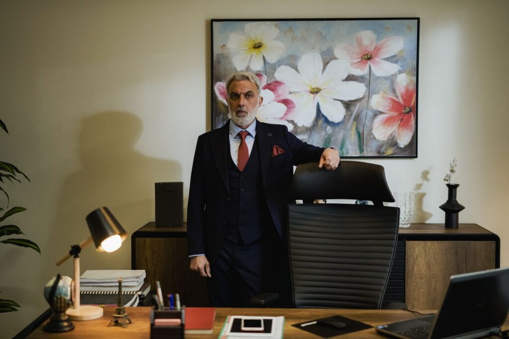 Distinguished mature businessman in a suit standing confidently in a modern office.